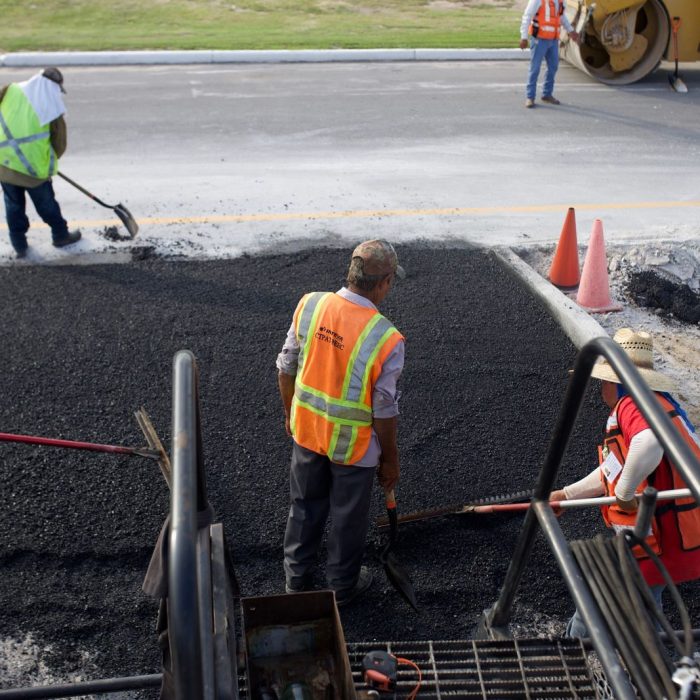 Road construction crew laying asphalt